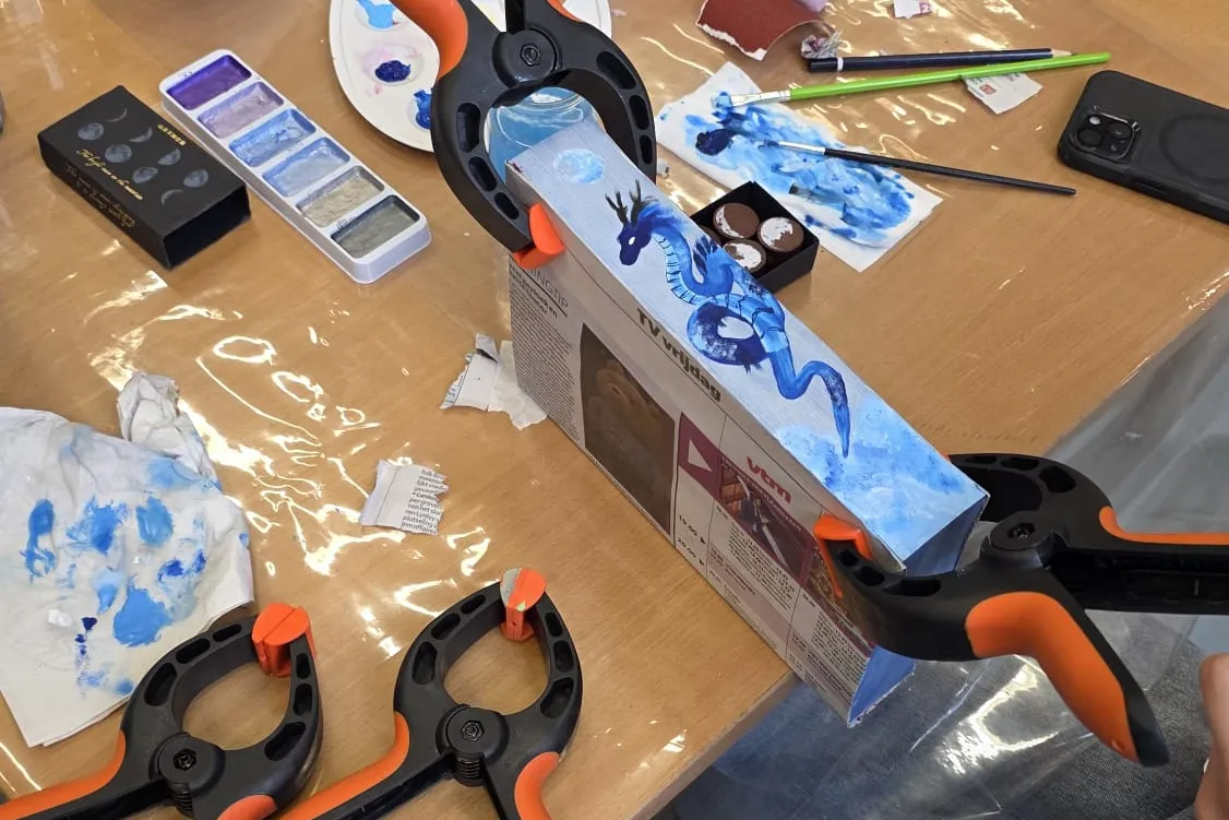 boek met geschilderde zijkant op werktafel met verfspullen