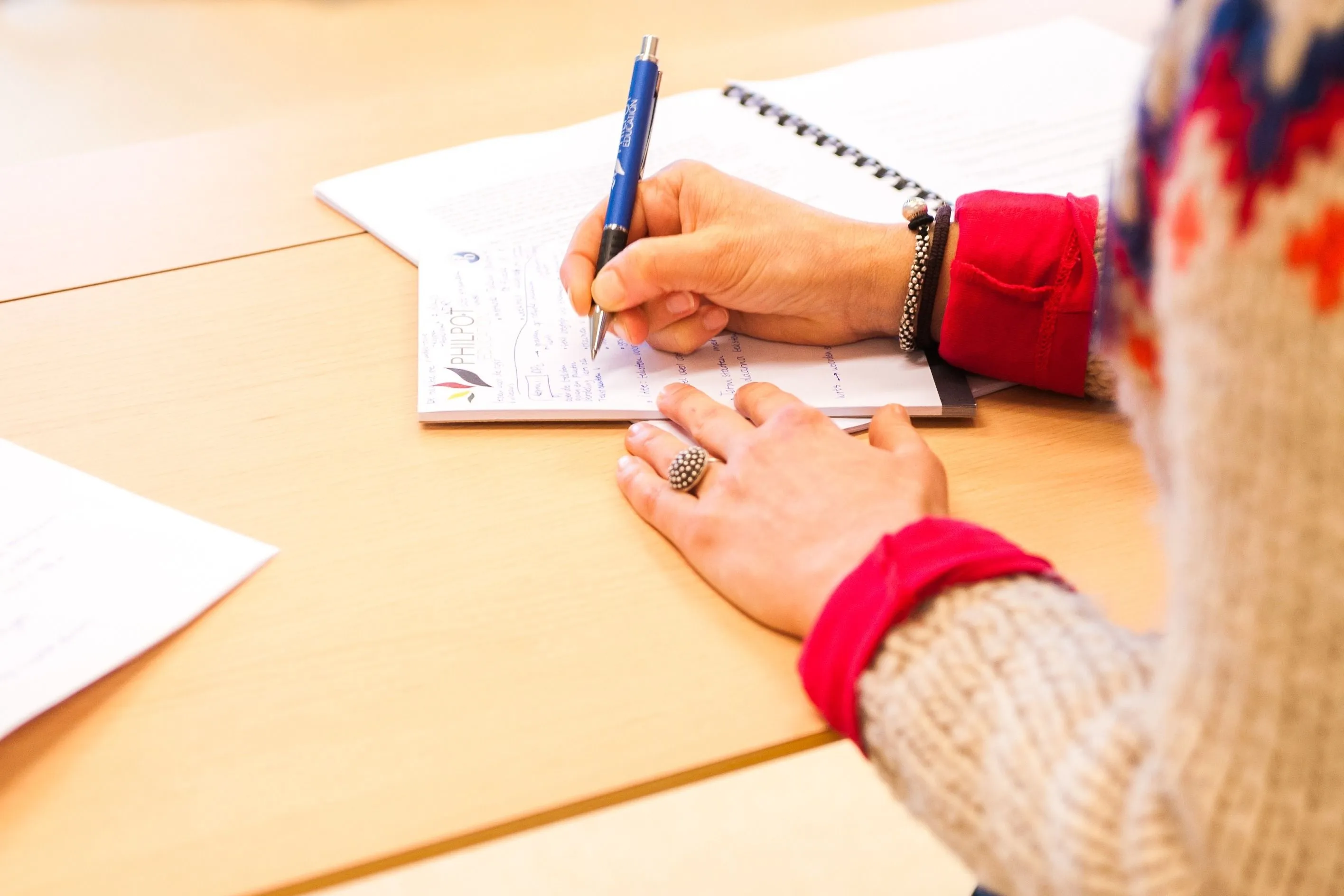 iemand zit te schrijven aan tafel