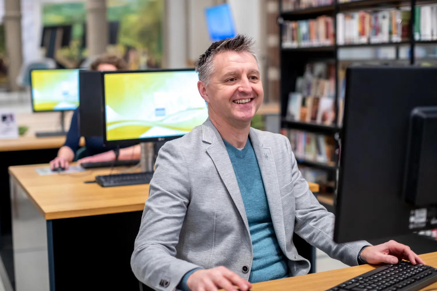lachende man achter computer 