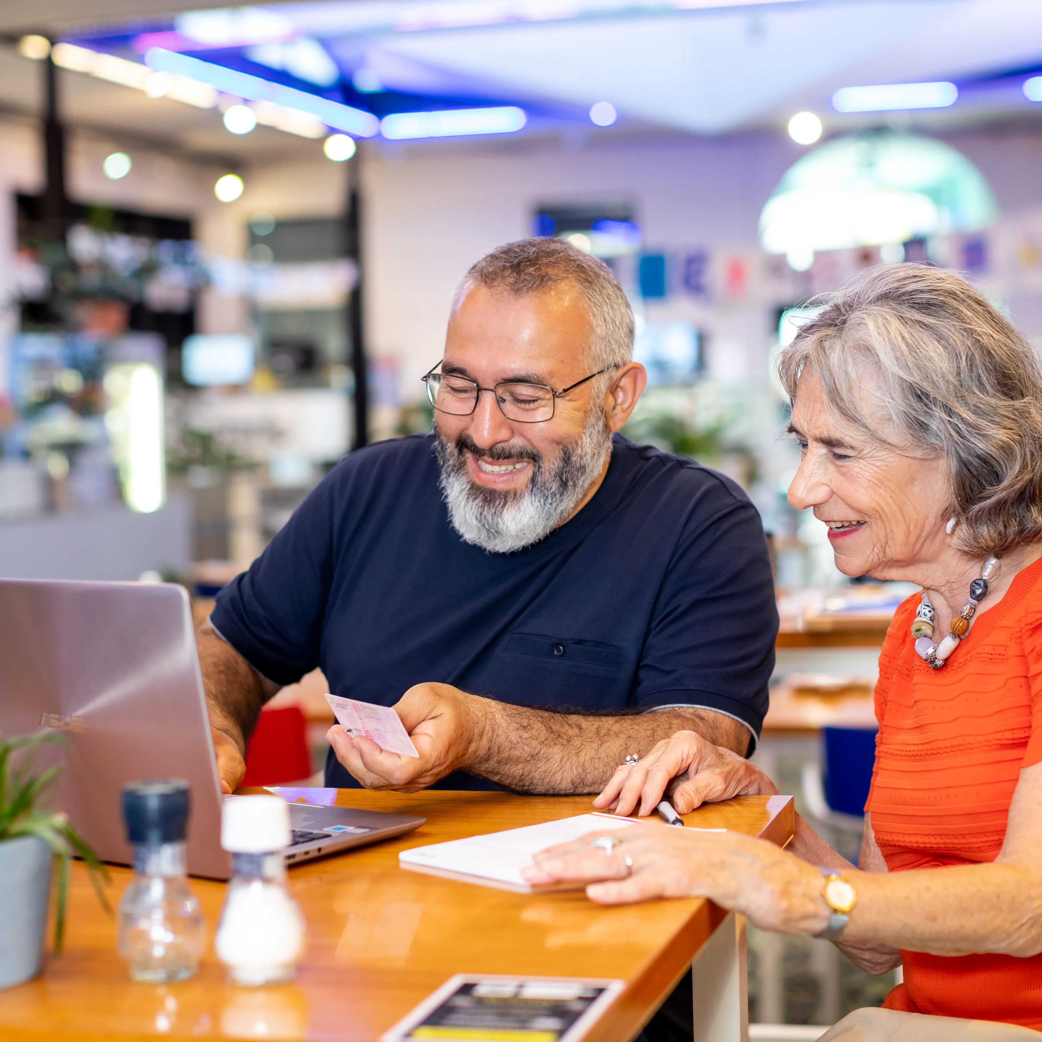 man en vrouw aan tafel achter laptop