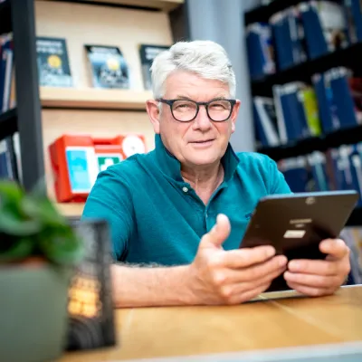 Man met ipad aan tafel 