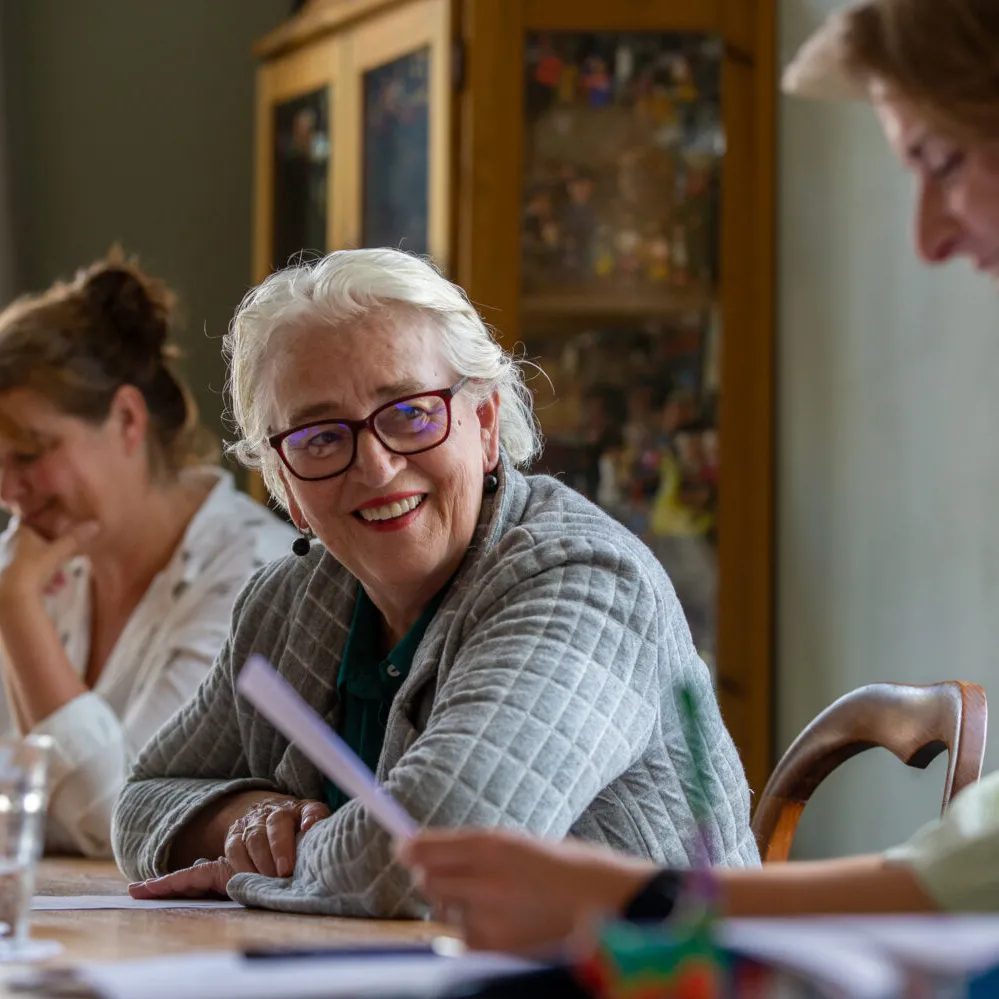 vrouwen rond tafel lezen en praten met eklaar
