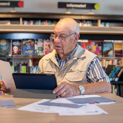 Man achter laptop met belastingenvelop