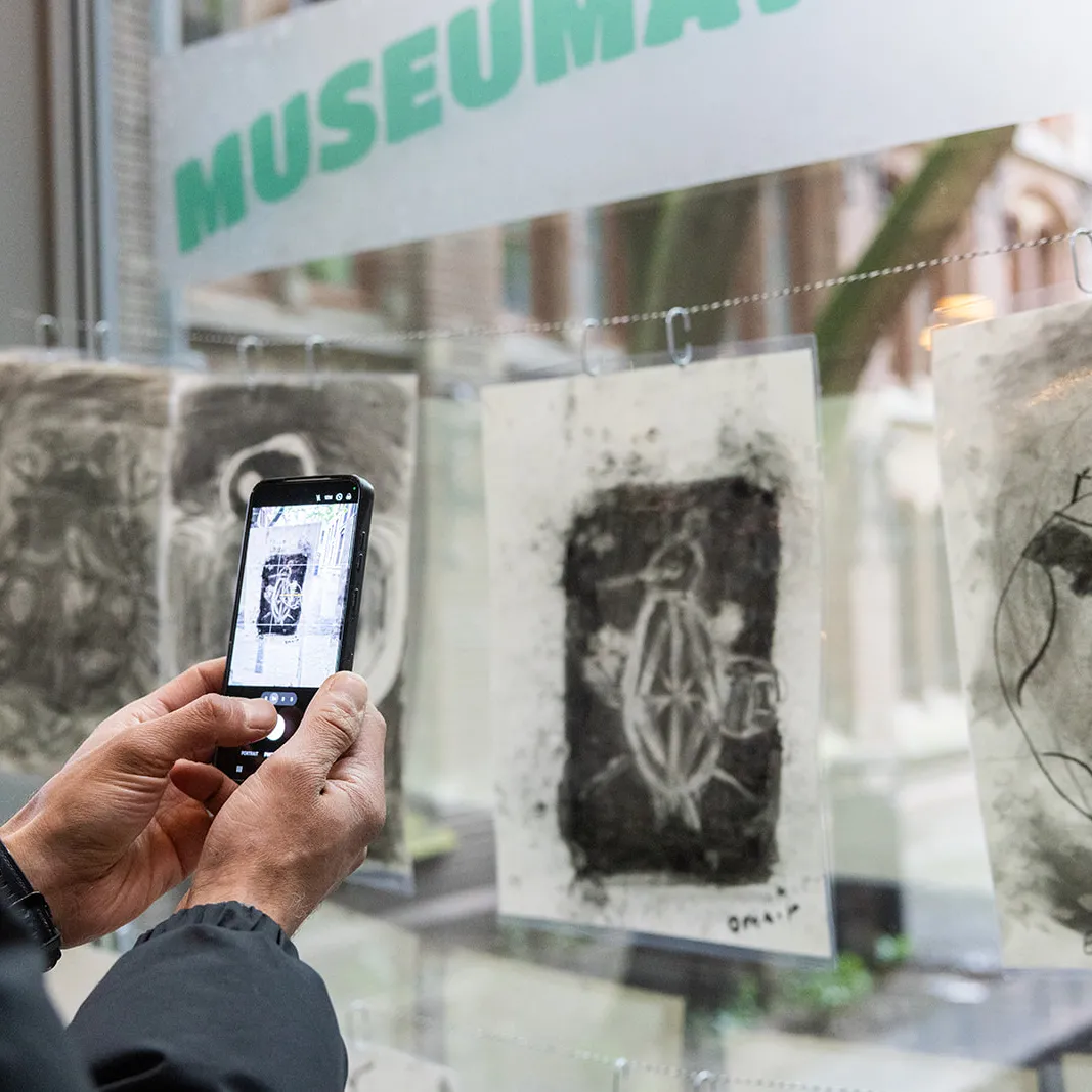 bezoeker maakt foto met telefoon van kunstwerk