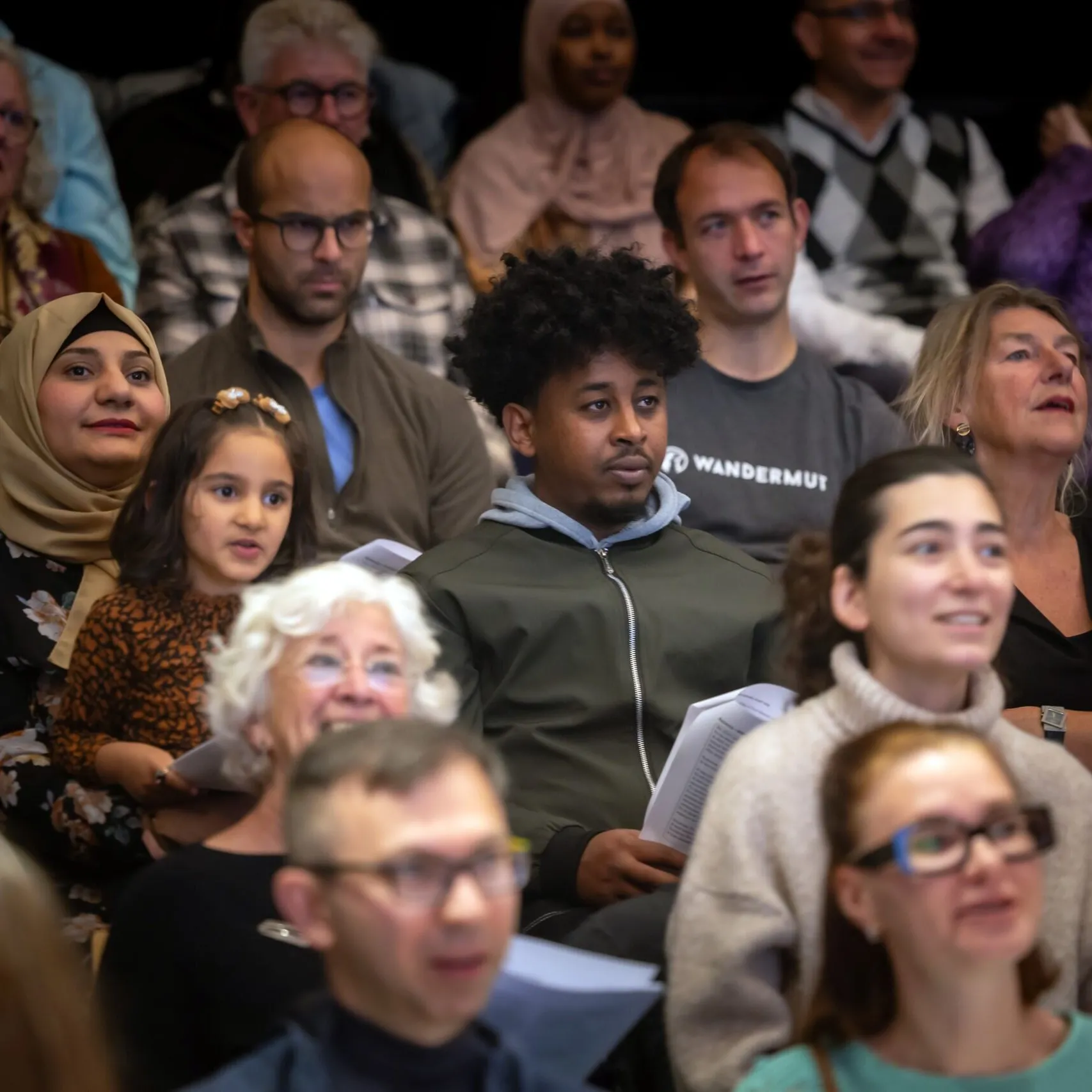 Verschillende mensen in een publiek die meezingen