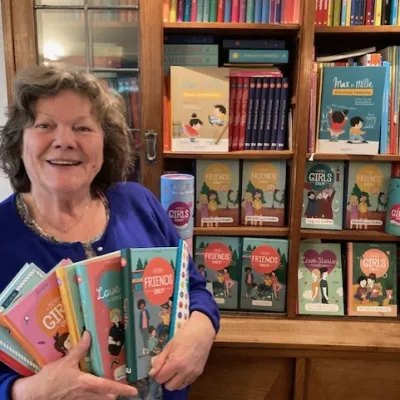 Hetty met haar boeken bij de boekenkast