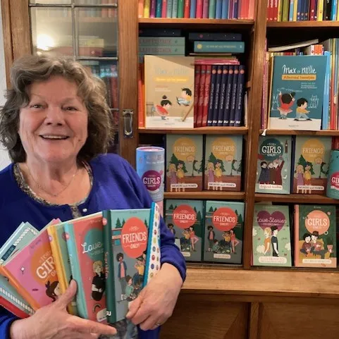 Hetty met haar boeken bij de boekenkast