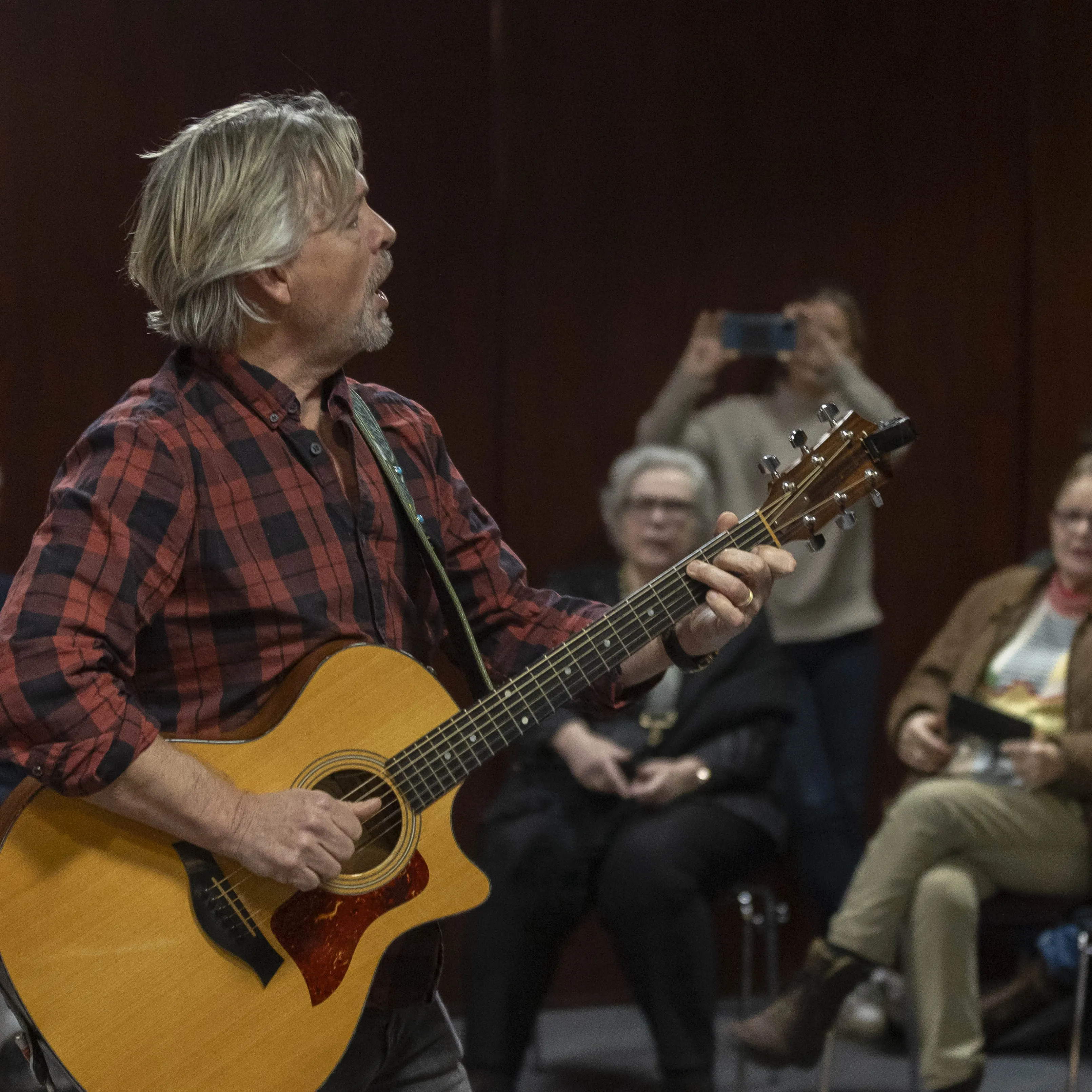 Man met gitaar en publiek
