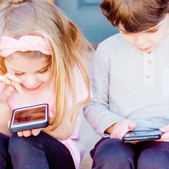 twee kinderen op hun mobiel
