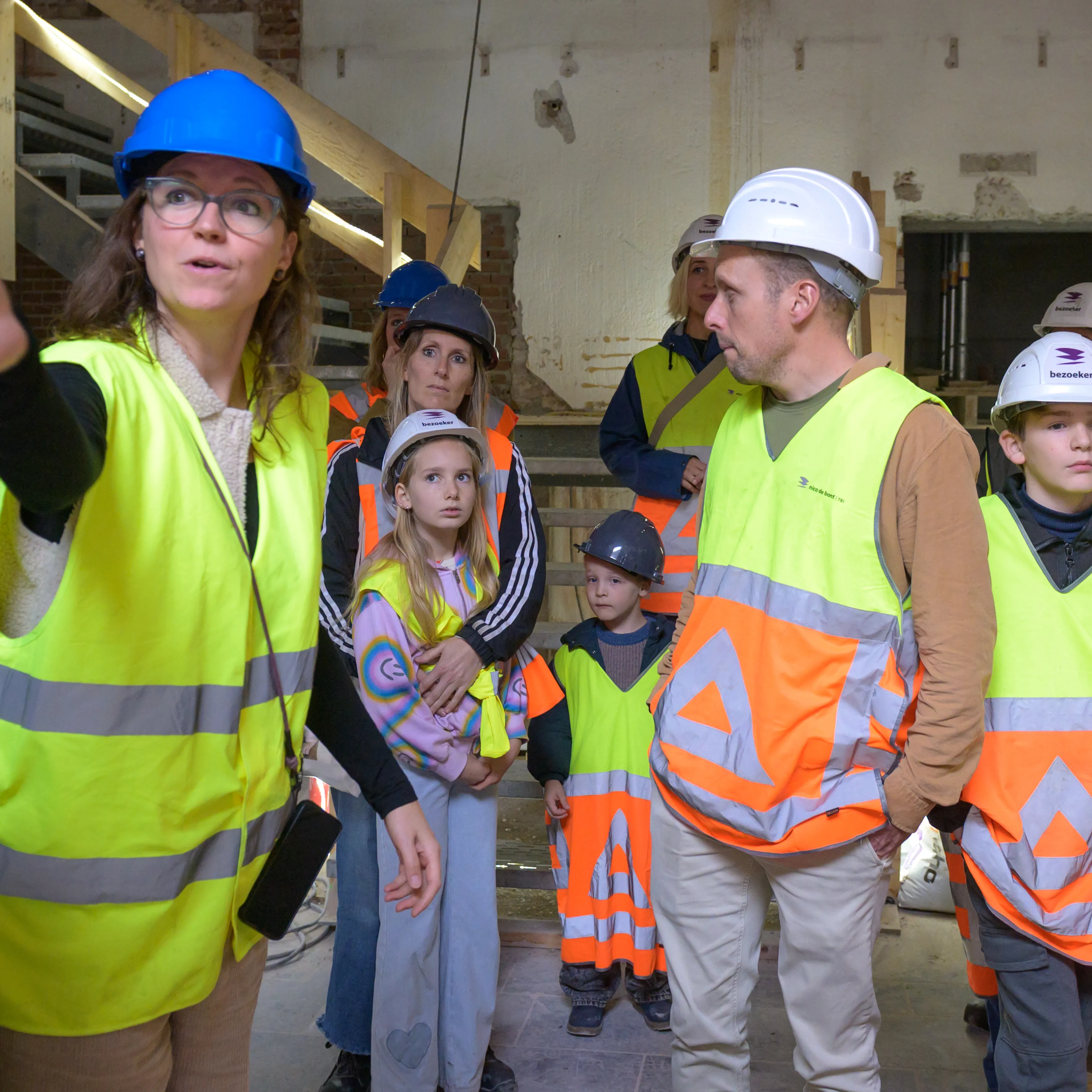 kinderen en hun ouders op de bouwplaats krijgen uitleg