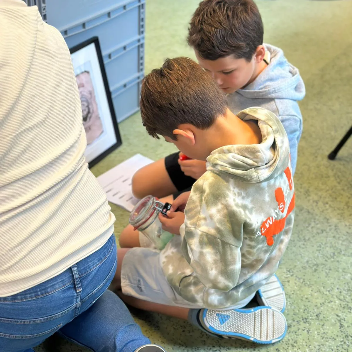 jongens doen opdracht op de grond