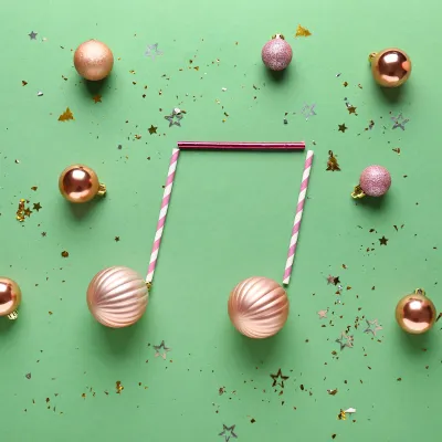 Groene achtergrond met kerstballen in vorm van muzieknoot