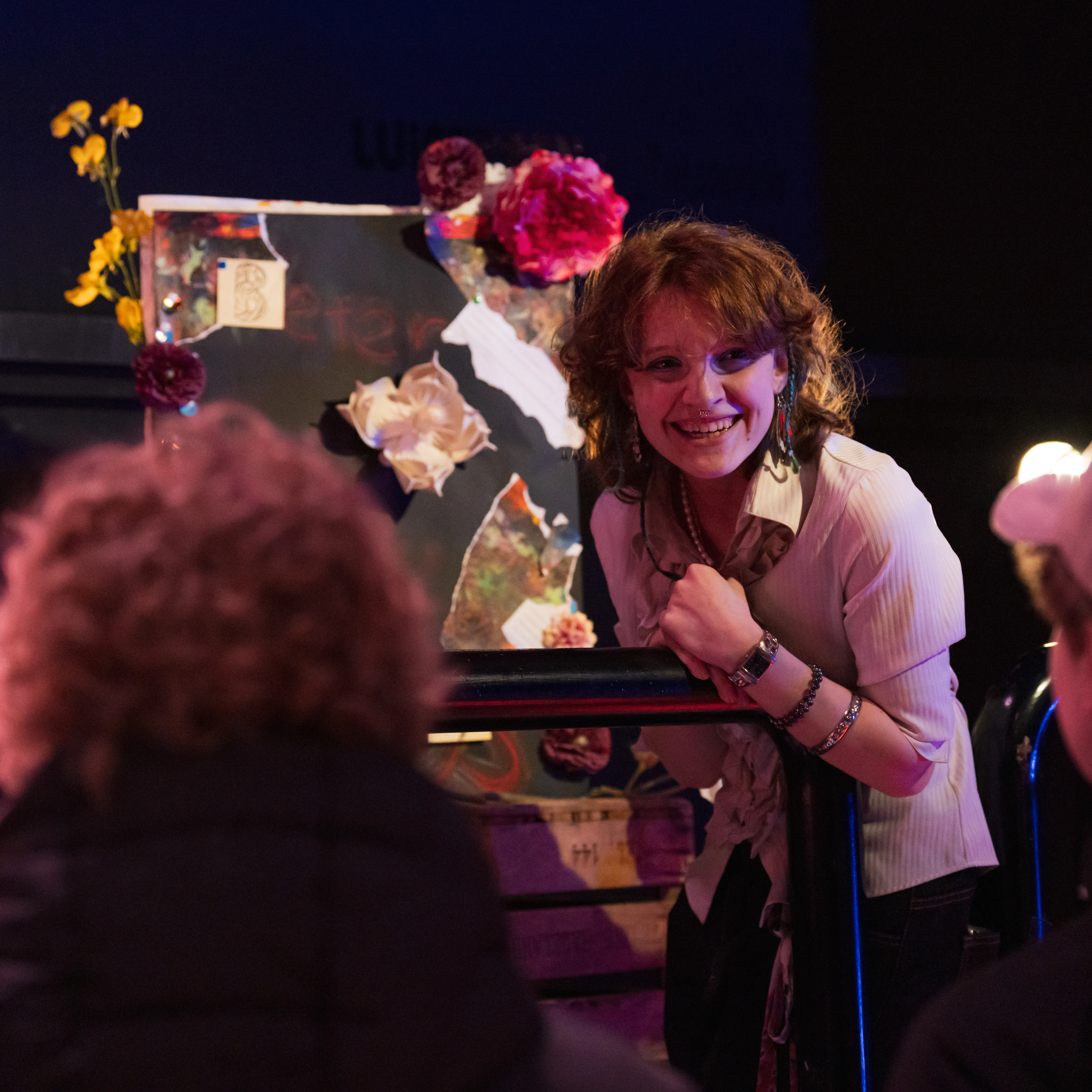 lachende jonge vrouw die haar kunst laat zien aan een publiek, kunstwerk met bloemen
