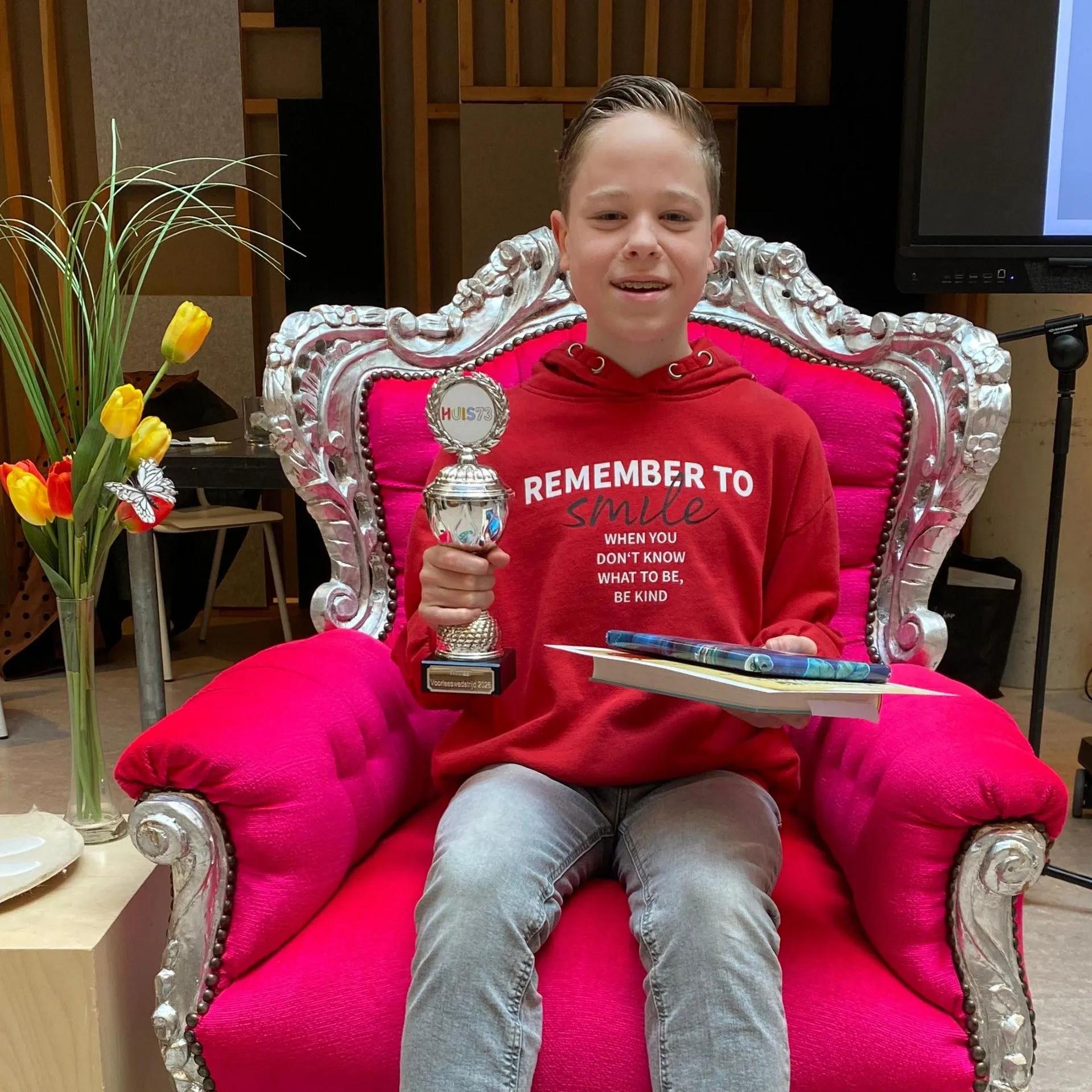 jongen met boek en prijs in feestelijke voorleesstoel