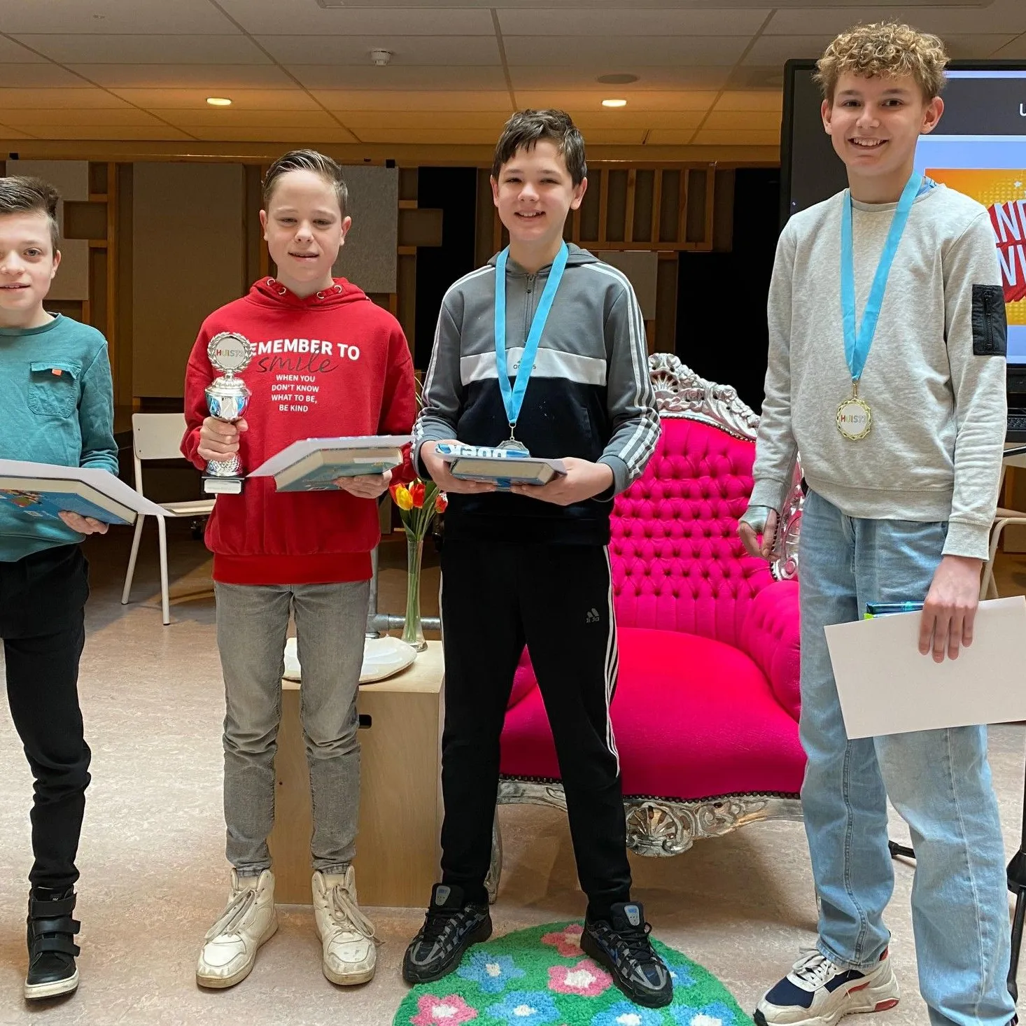 vier jongens met hun boek op podium