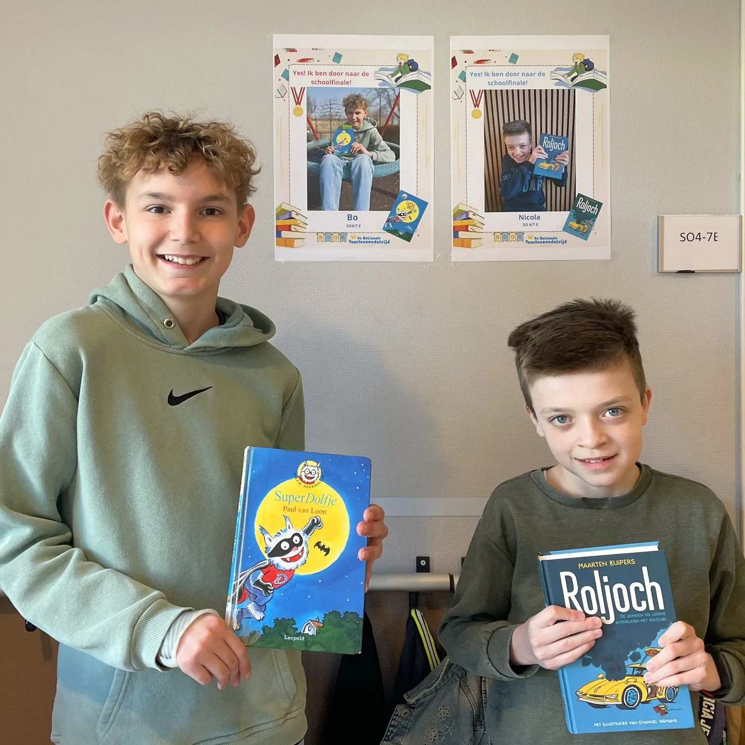 twee lachende jongens met hun boek