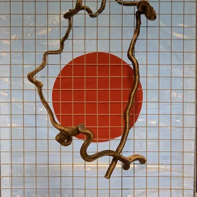 Kunstwerk met houten frame en rode cirkel in het midden