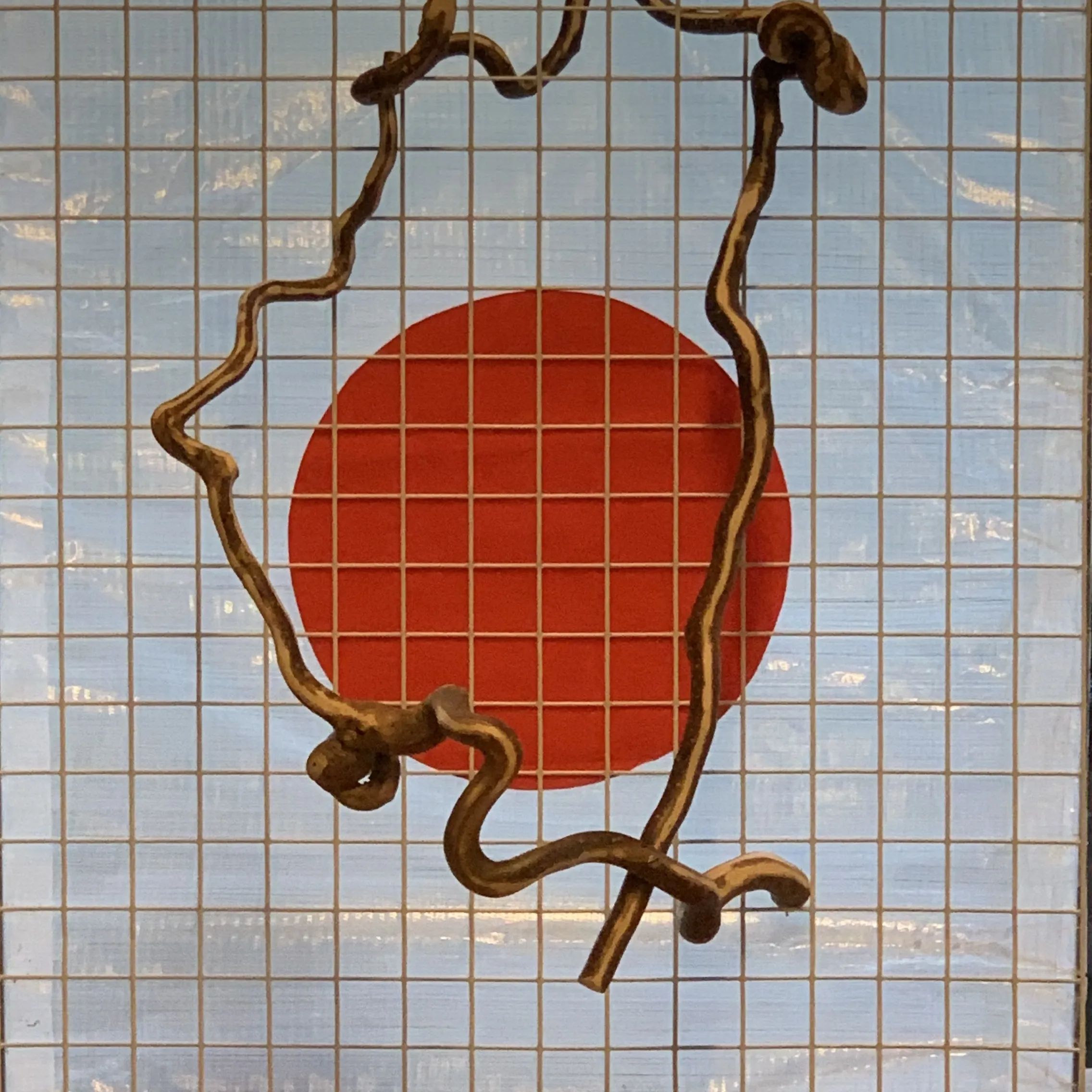 Kunstwerk met houten frame en rode cirkel in het midden