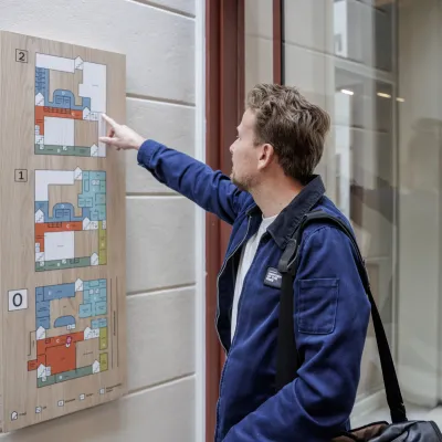jonge man met blauw jasje bij wegwijzerbord