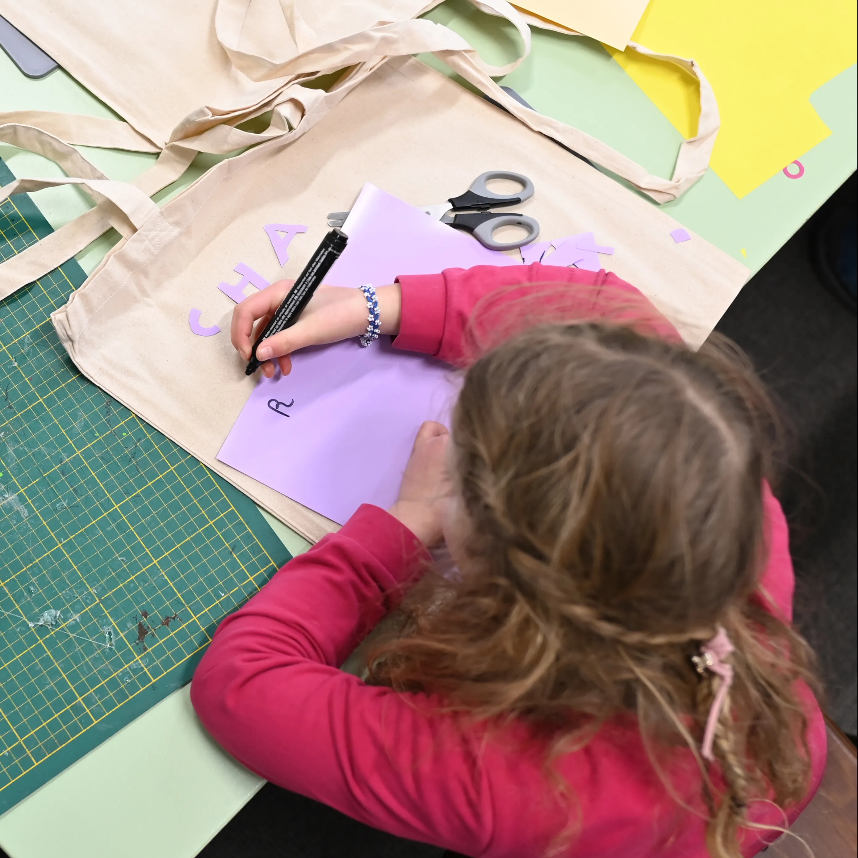 kind tekent op paars papier 