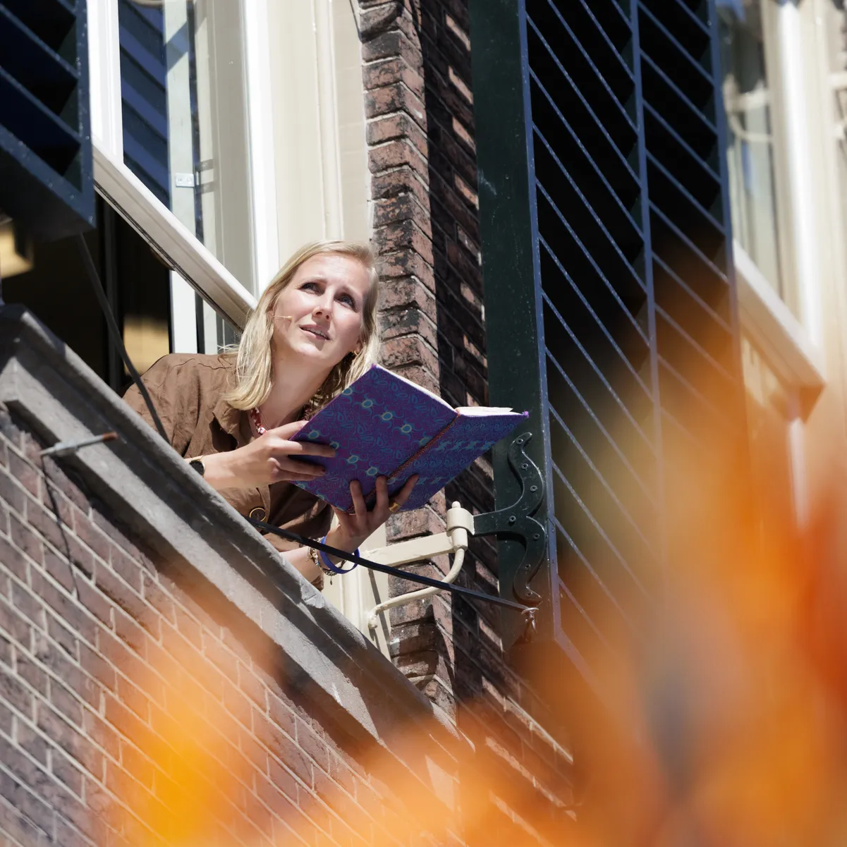 stadsdichter leest voor vanuit bovenraam
