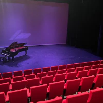 podium in theater met piano op de achtergrond
