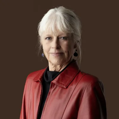 Portret van schrijfster Annegreet van Bergen. Grijze vrouw in rode jas