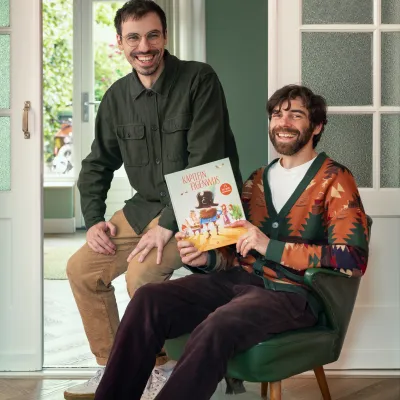 Broers Paul en Laury Tinnemans staan samen op de foto met hun zelfgeschreven boek Kapitein Eigenwijs