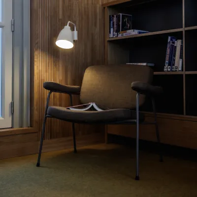 foto van stoel met boek op z'n kop en lampje dat schijnt