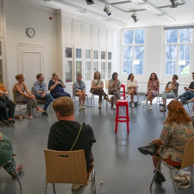 Groep zit in cirkel voor panelgesprek