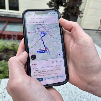 Handen met mobiele telefoon en google maps
