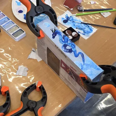boek met geschilderde zijkant op werktafel met verfspullen
