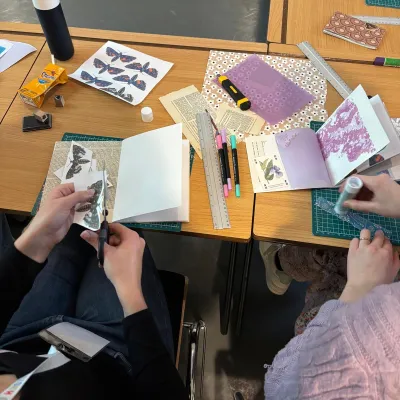 Twee personen werken aan een scrapboek