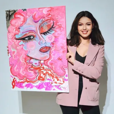 Foto van vrouw die schilderij (roze) vasthoudt
