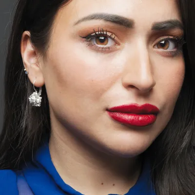Jonge vrouw met rode lippen en donker haar.