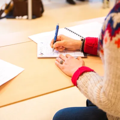 iemand zit te schrijven aan tafel