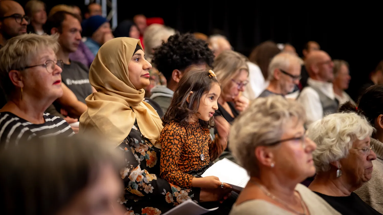 foto van zijaanzicht gevarieerd publiek in zaal