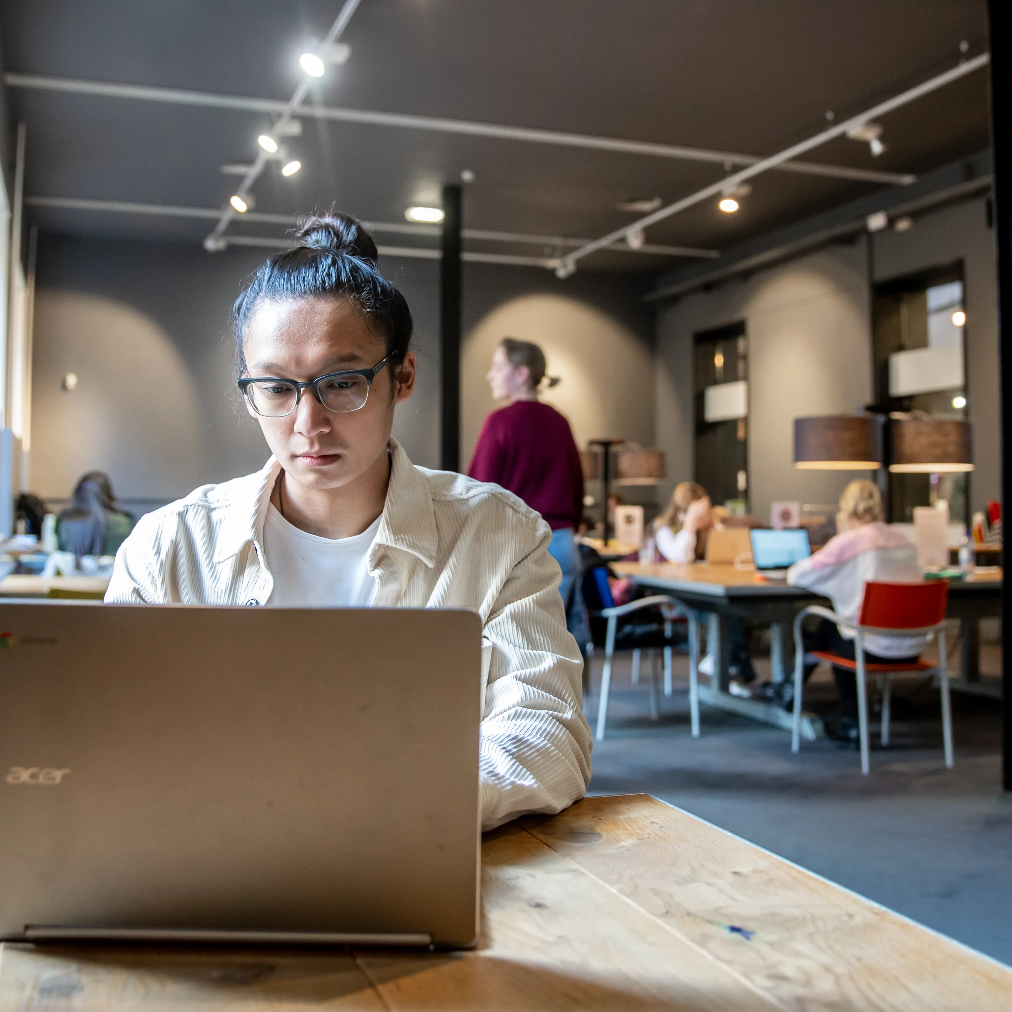 jongen achter computer in studiezaal
